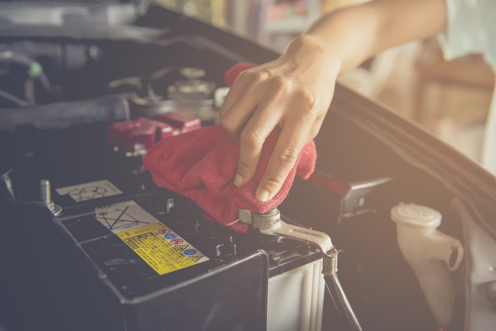 A technician wiping down an engine with a microfiber cloth during a service appointment